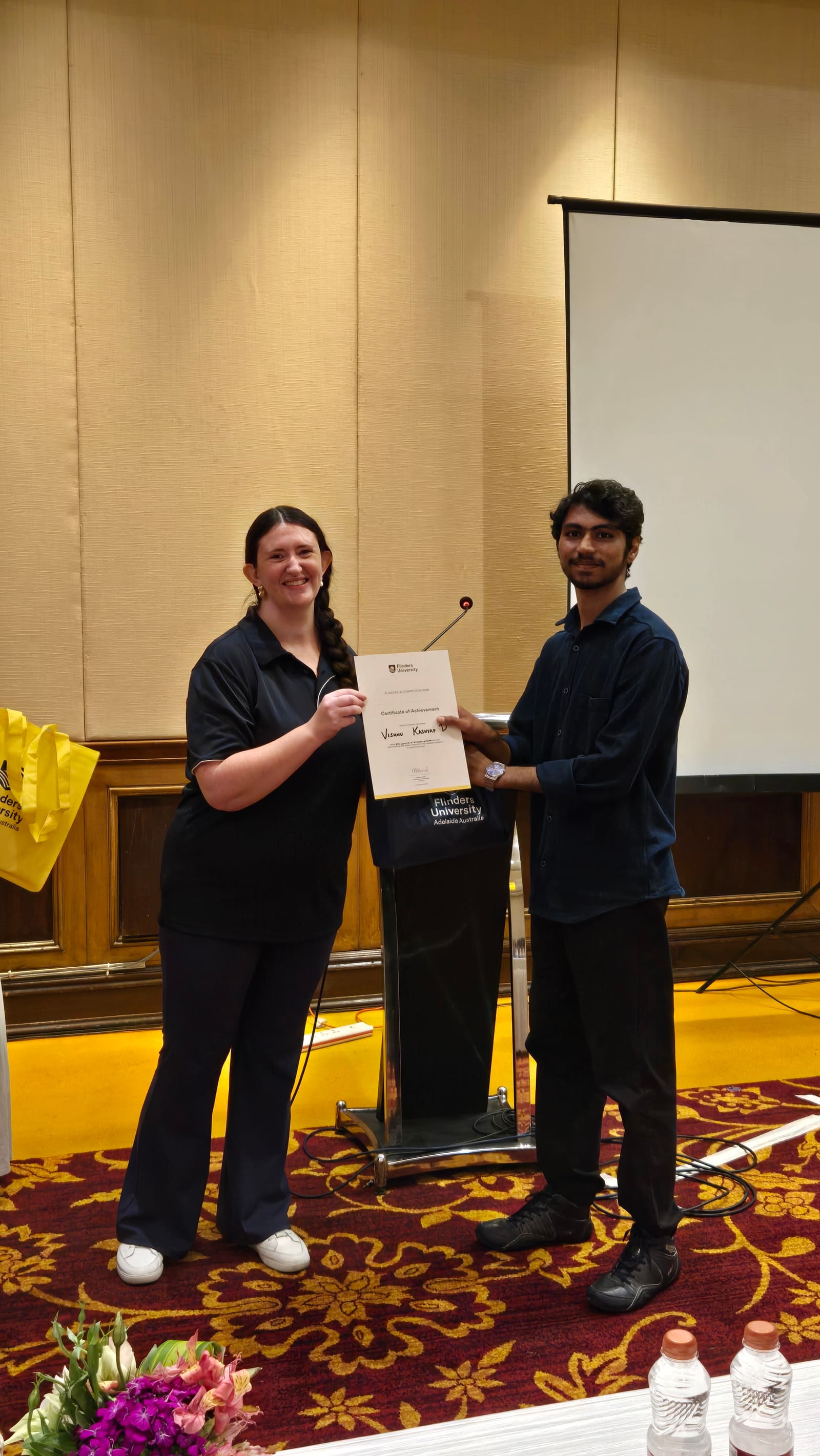 Receiving the certificate of achievement from a Flinders University representative