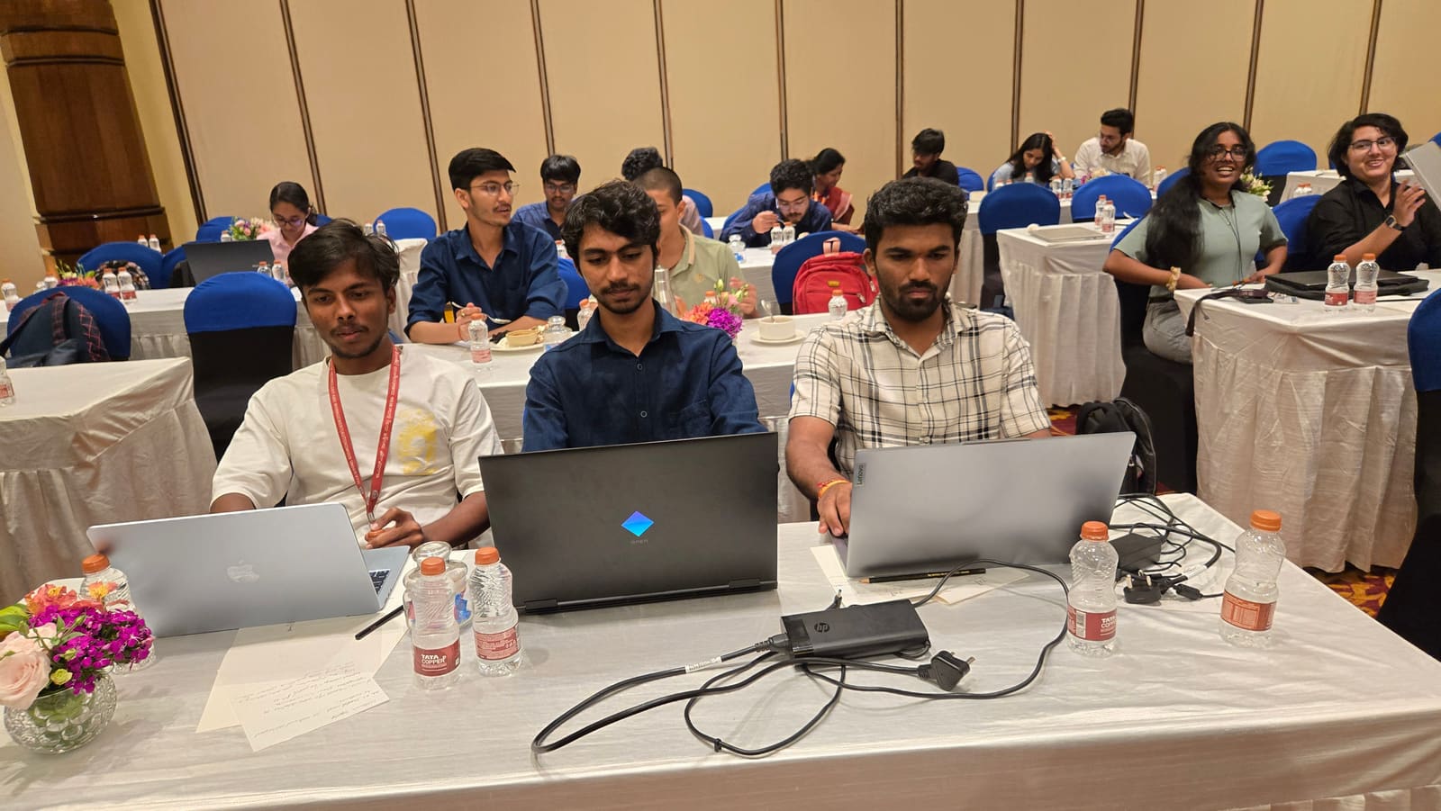The team continuing development during the hackathon, working alongside other teams in the competition hall